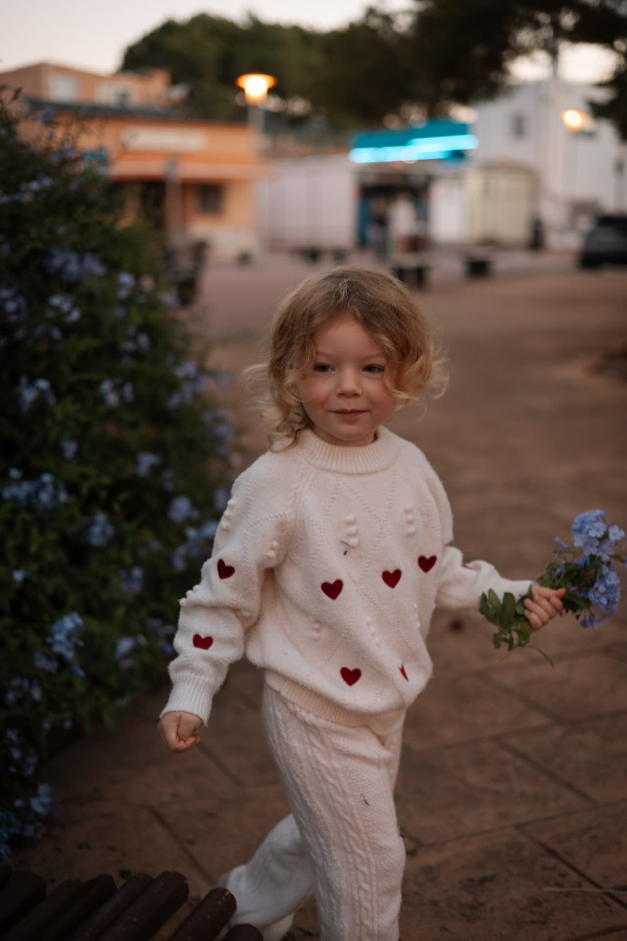 Kind loopt met een bosje bloemen over de camping